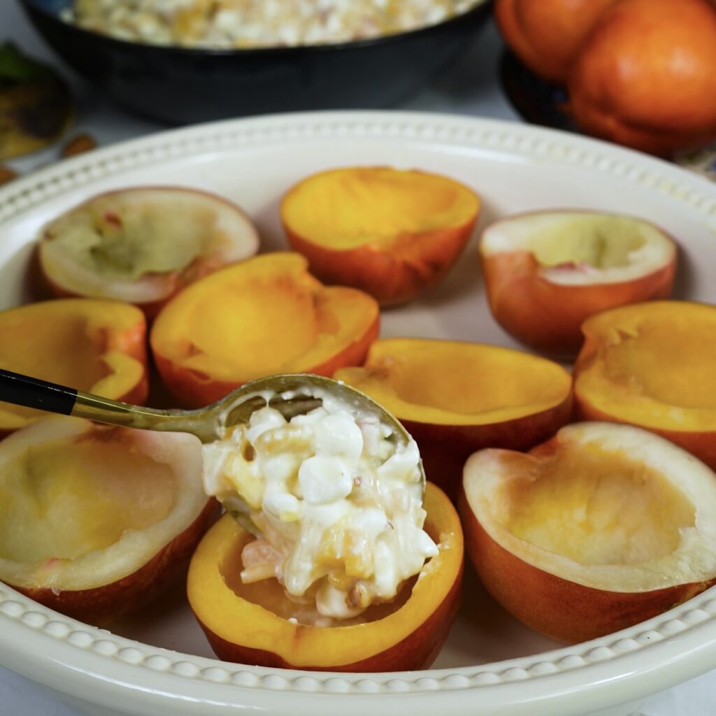 Scooped-out nectarine being filled with a honeyed cottage cheese mixture.