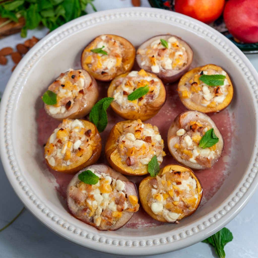 Baked nectarines in a baking dish, golden and caramelised, ready to serve.