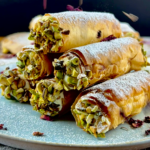 Crispy phyllo tubes filled with cream cheese and topped with chopped pistachios.