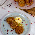 Mini pistachio baklava rolls served with a scoop of ice cream.