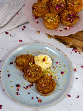 Mini pistachio baklava rolls served with a scoop of ice cream.