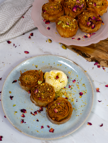 Mini pistachio baklava rolls served with a scoop of ice cream.