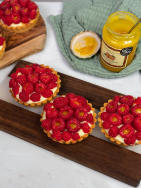 Passion Fruit Curd and Raspberry Tarts topped with fresh raspberries and curd.