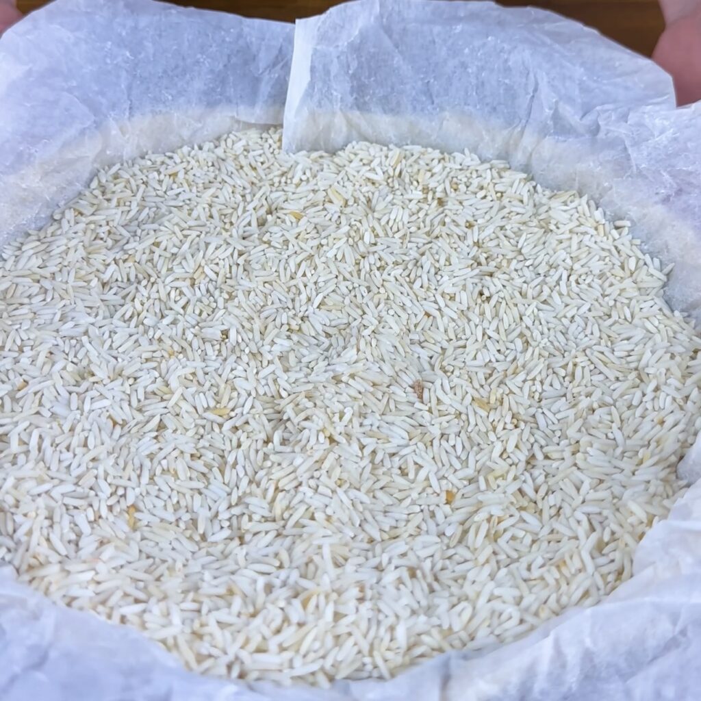 Tart base lined with baking paper and filled with uncooked rice