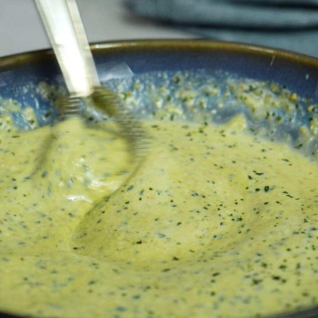 Mixing pesto ricotta custard in a bowl