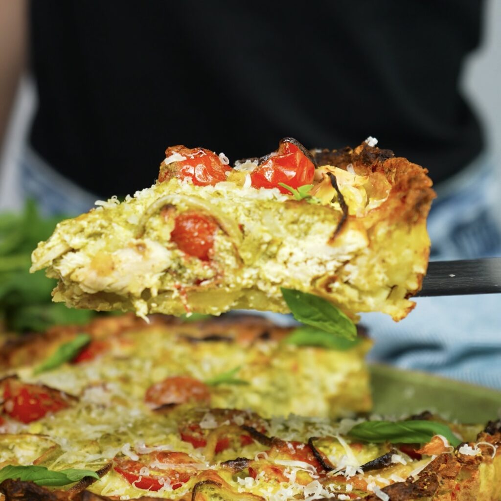 Slice of crushed potato quiche with chicken and pesto