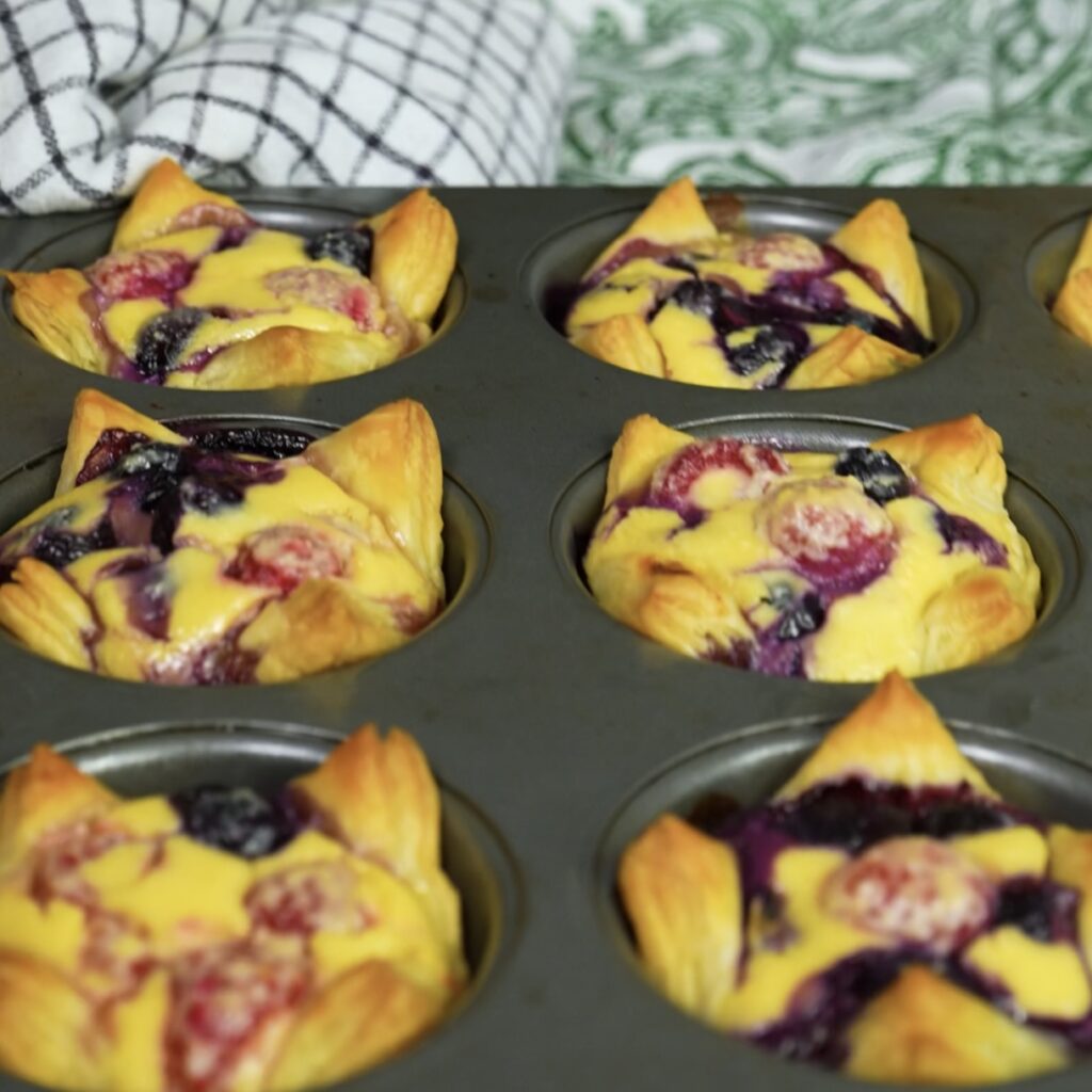 Freshly baked cottage cheese and berry tartlets in a muffin tin