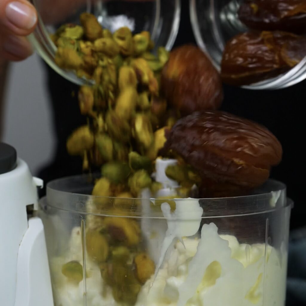 Cottage cheese, dates, and pistachios in a blender ready to be mixed