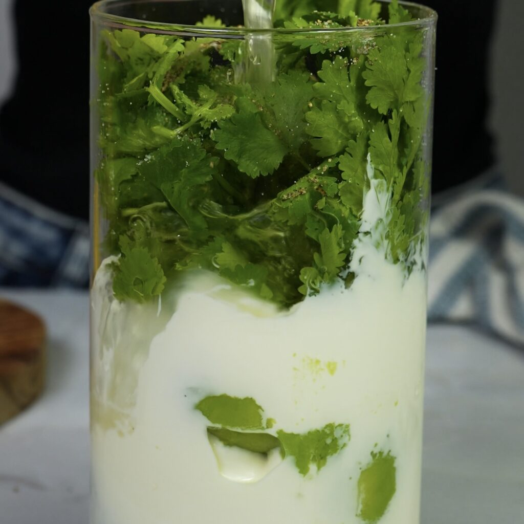 Blending avocado, yoghurt, coriander, and lemon juice for chilled soup