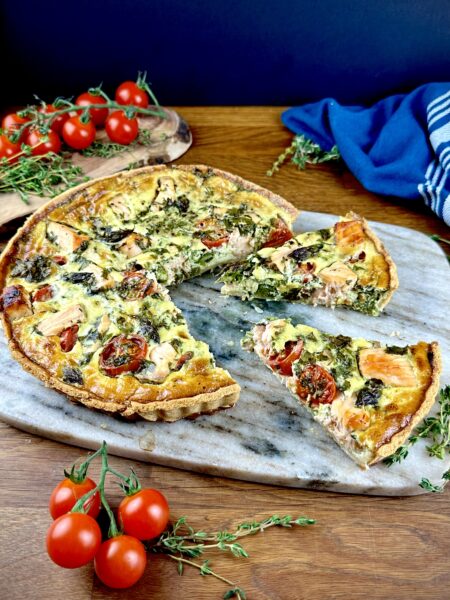 Salmon and asparagus quiche with two slices cut and slightly pulled out