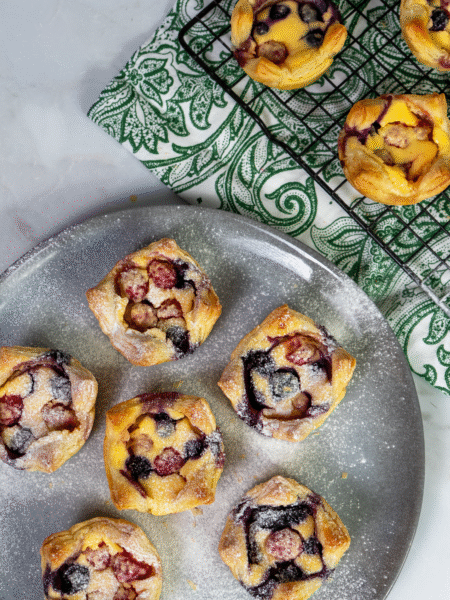 Cottage cheese berry tartlets dusted with icing sugar on a serving plate