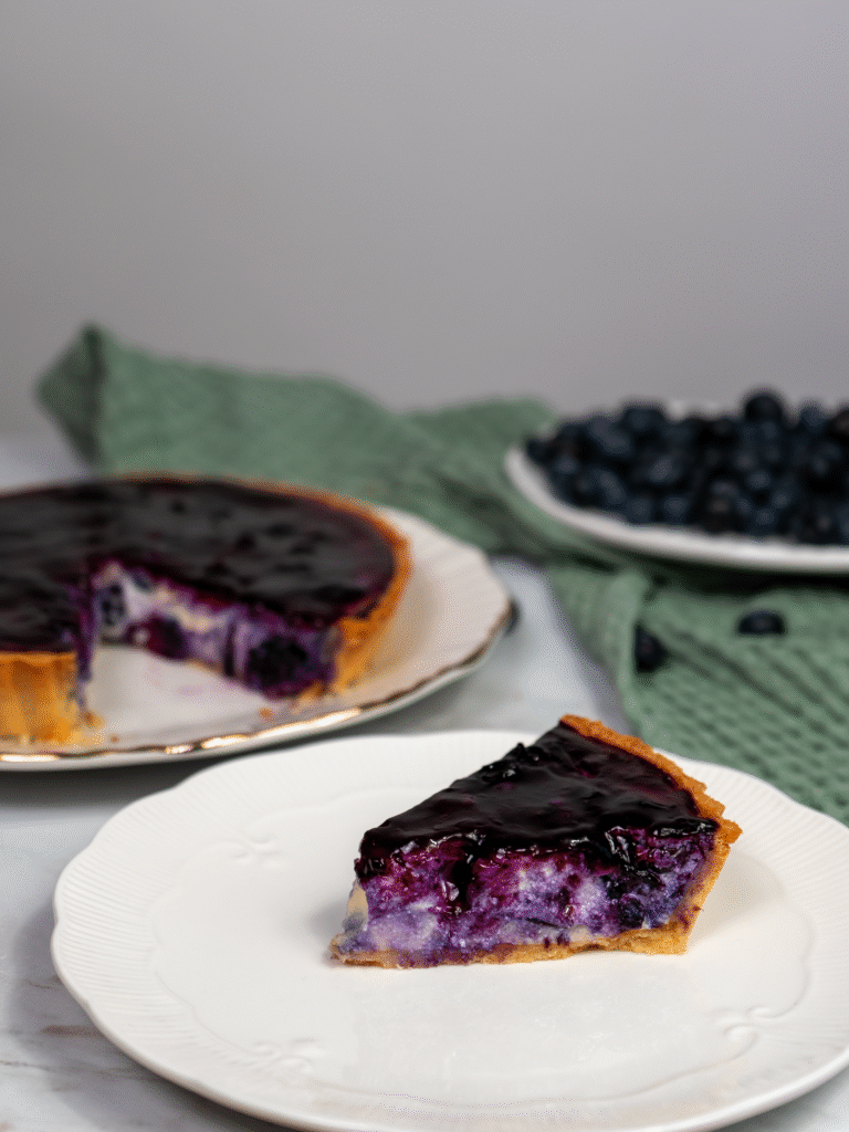 Slice of blueberry ricotta tart on a plate