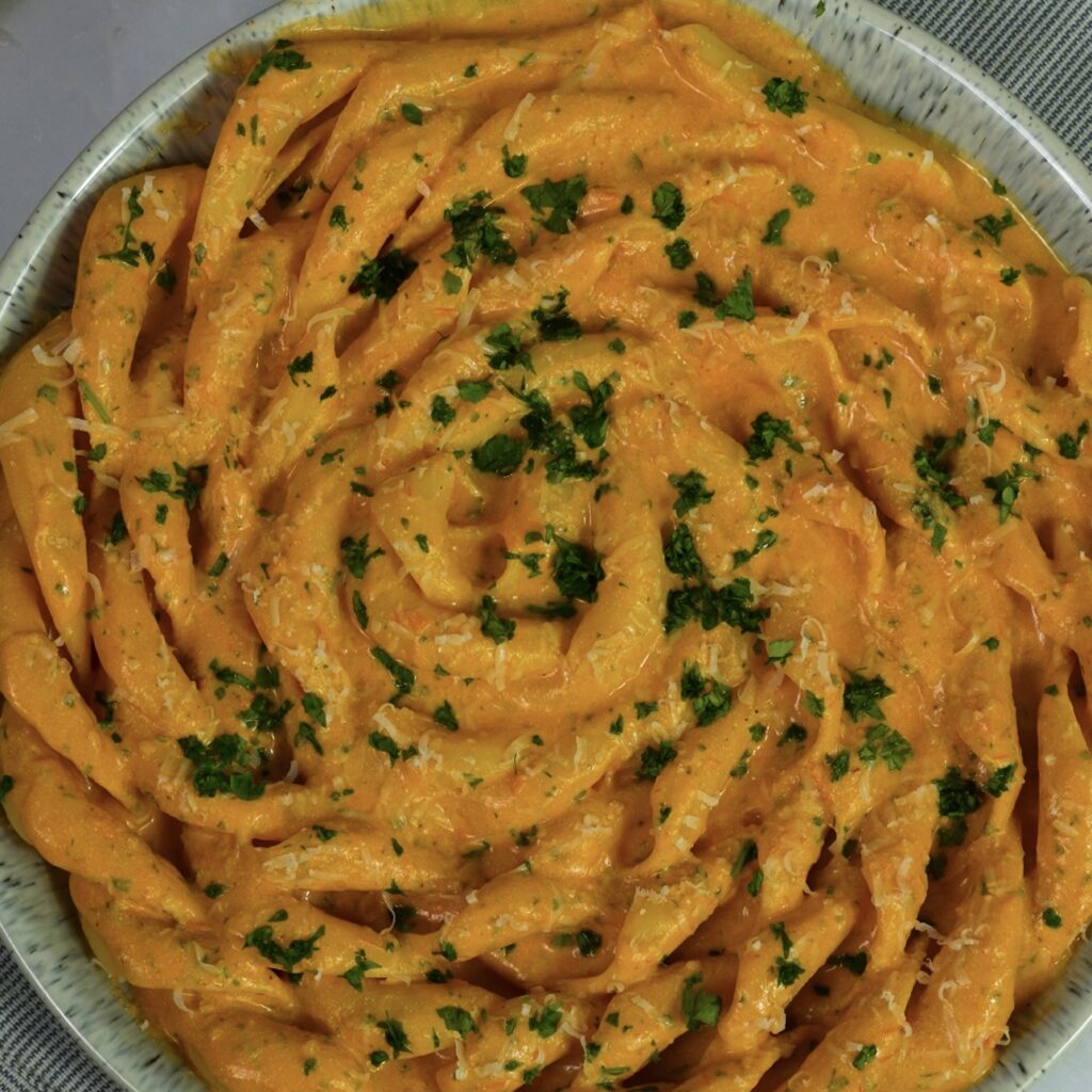 Creamy roasted tomato and cottage cheese fusilli served on a plate