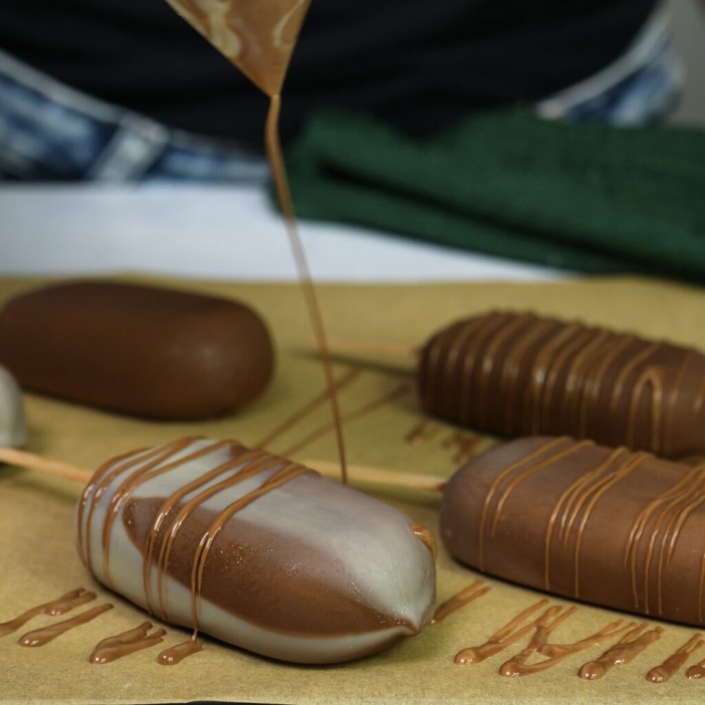Drizzling chocolate over cherry ice creams