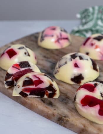 Glossy mosaic jelly domes with berry cubes suspended in creamy vanilla