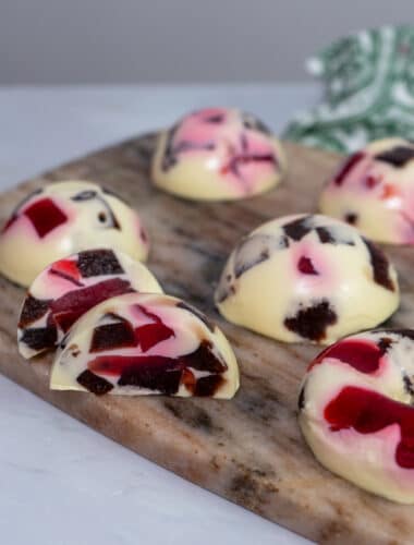Glossy mosaic jelly domes with berry cubes suspended in creamy vanilla