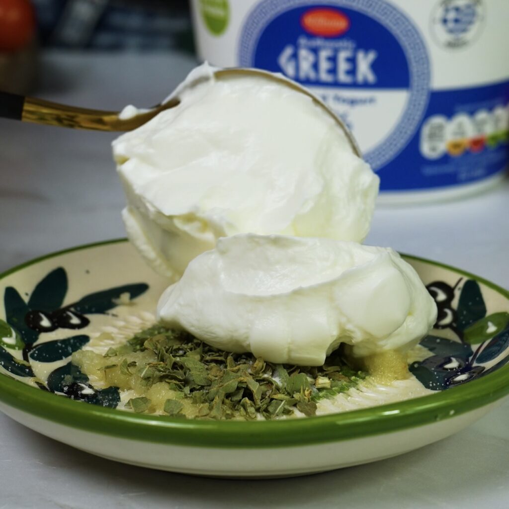 Mixing garlic yoghurt dip in a bowl.