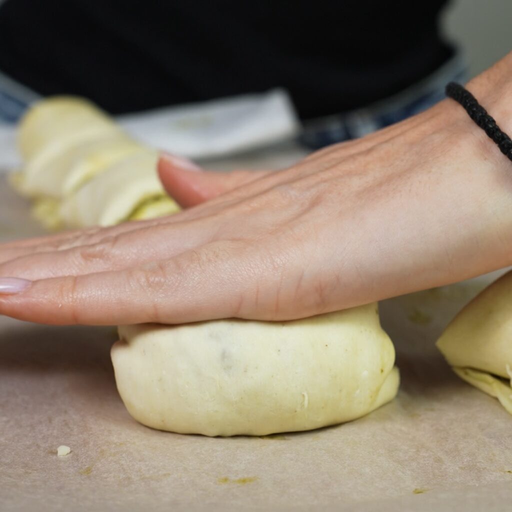 Flattening the folded puff pastry gently with the palm of the hand.