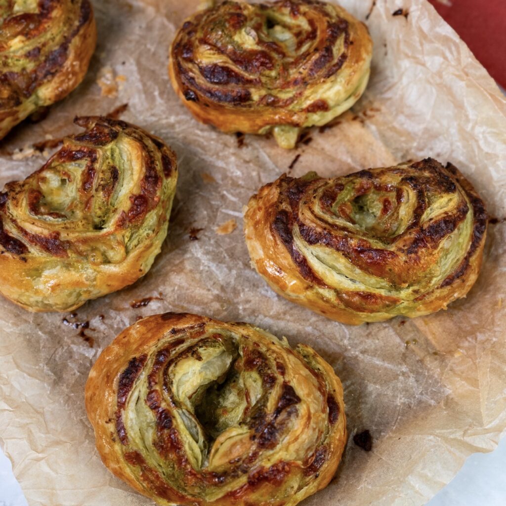 Freshly baked Cheesy Pesto Puff Buns on parchment paper