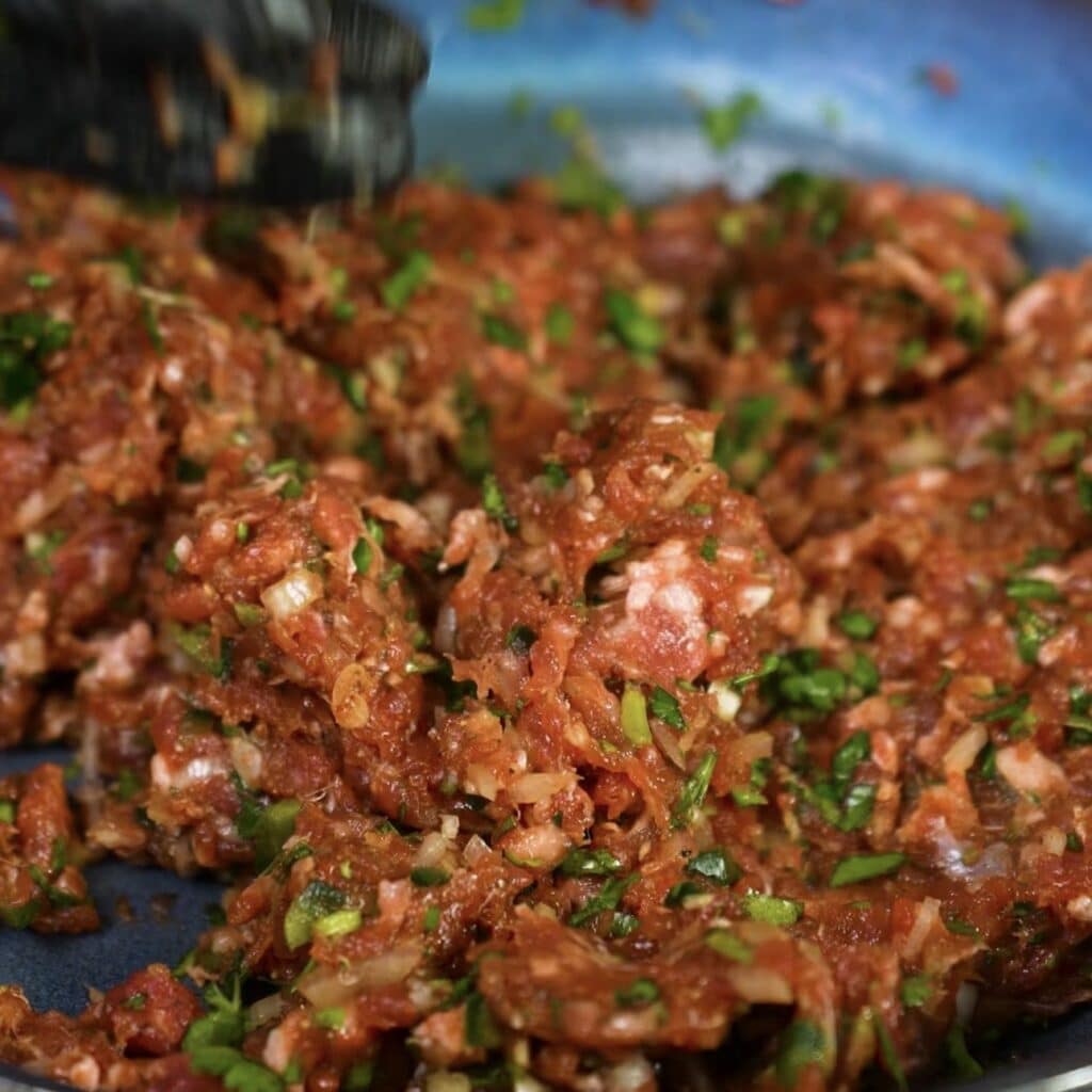Mixing spiced minced beef filling in a bowl