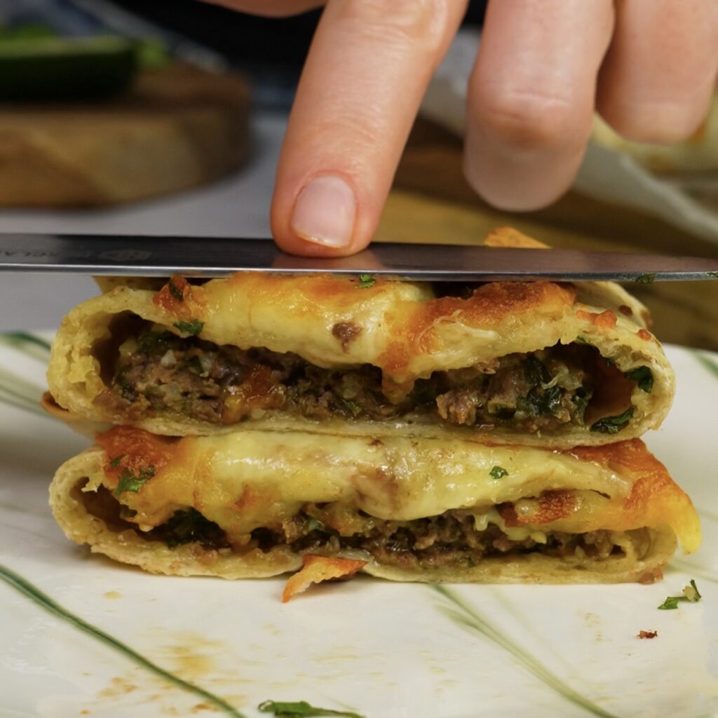 Tortilla parcel cut in half showing the spiced beef filling.