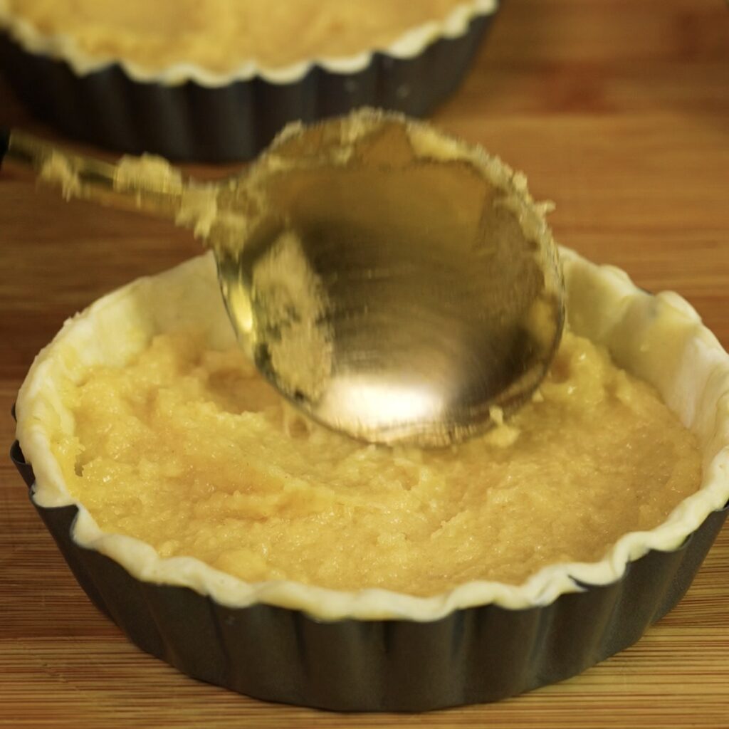 Adding almond frangipane filling to puff pastry tartlet cases