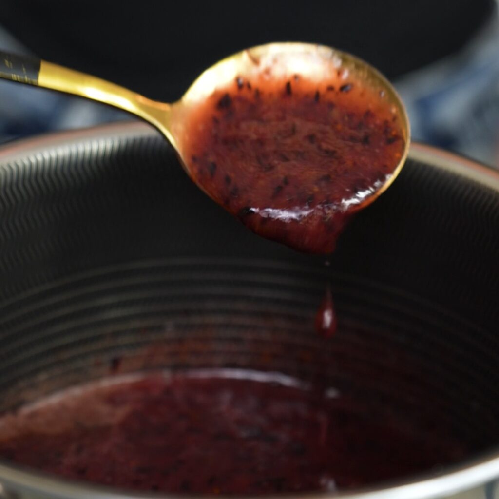 Blended blueberries being cooked into blueberry syrup in a saucepan