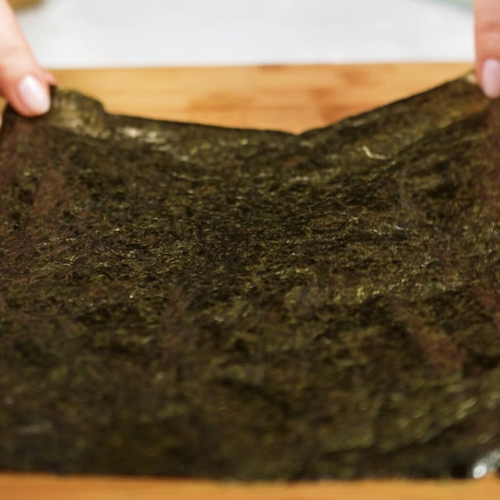 Flipping the nori and rice paper base before adding the salmon mixture