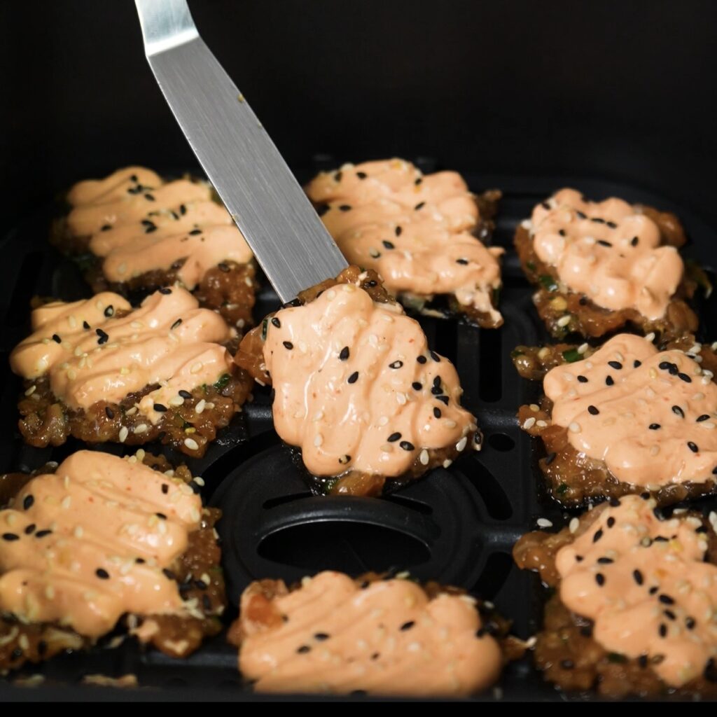 Arranging salmon squares in the air fryer basket in a single layer