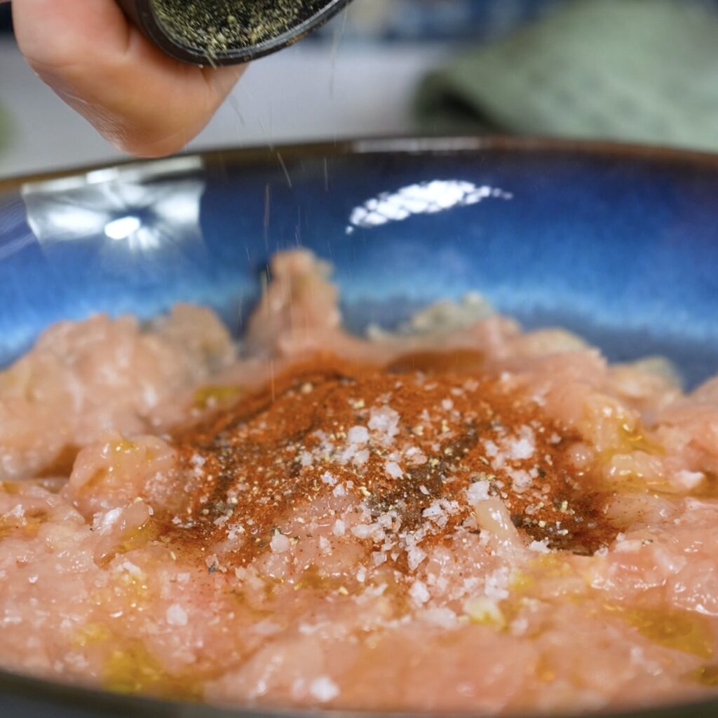 Seasoning minced chicken in a bowl 