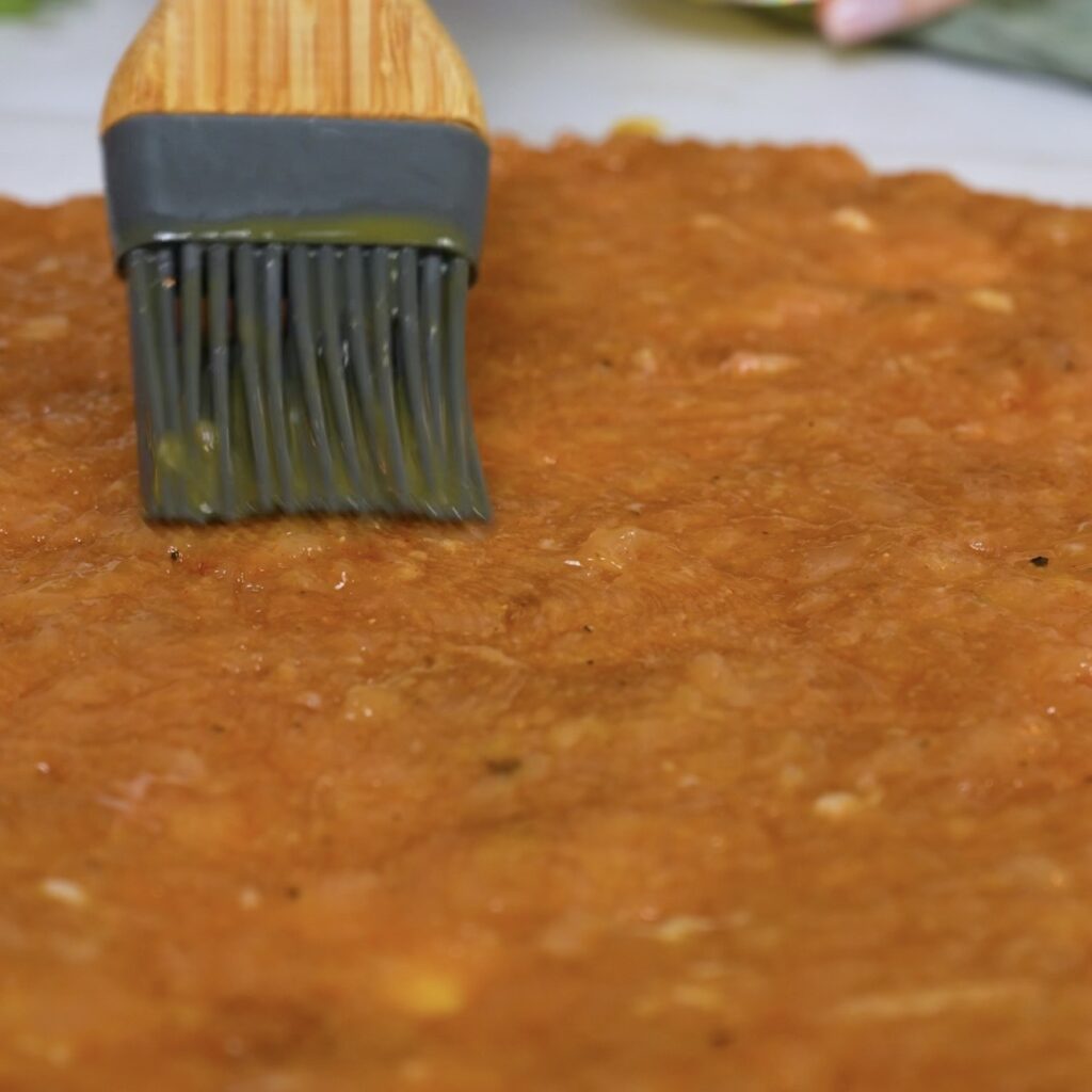 Brushing the chicken wrap base with egg yolk