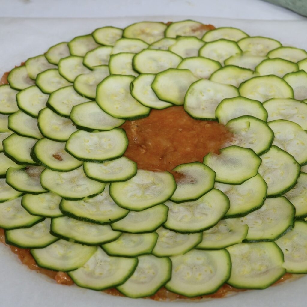 Arranging courgette slices over the chicken wrap base