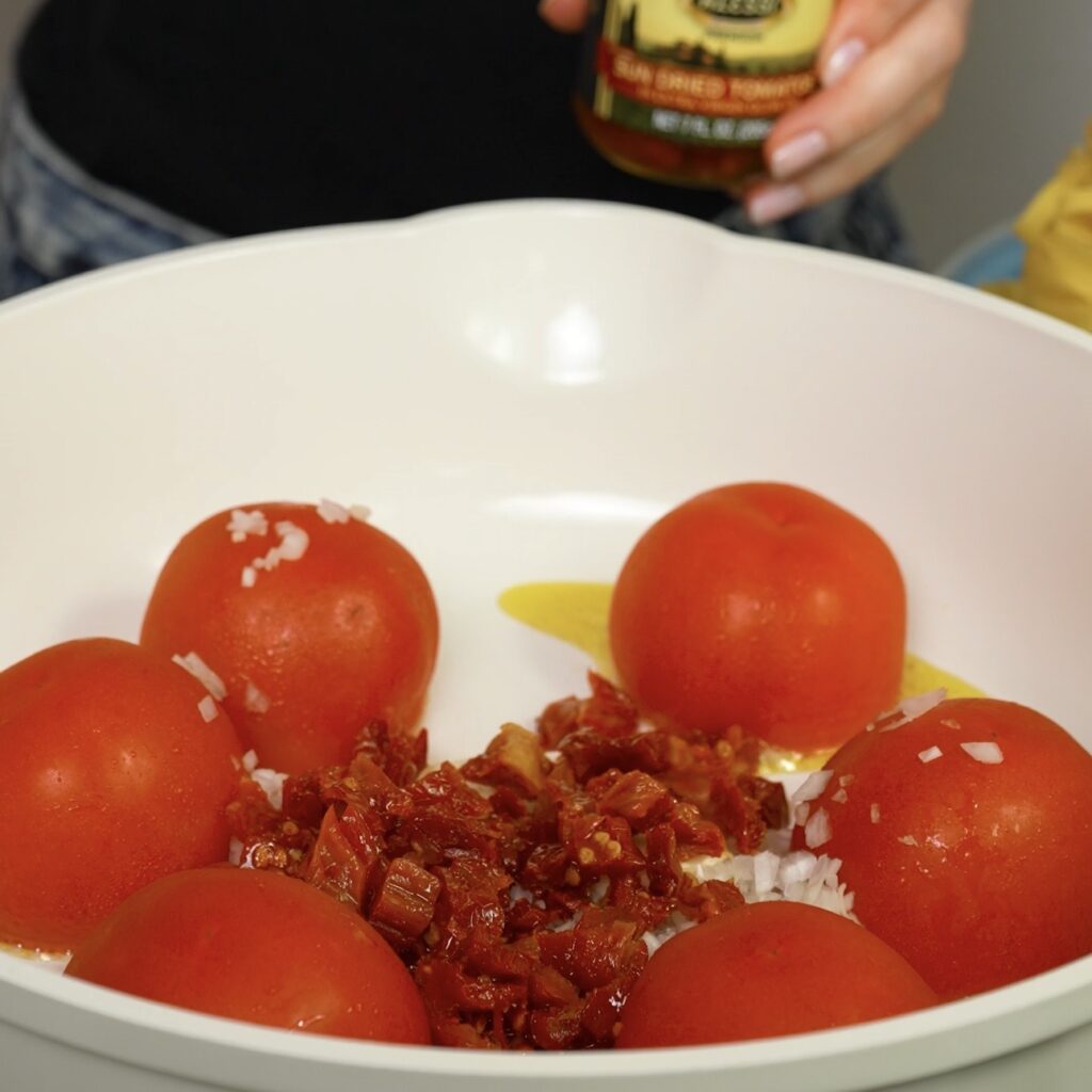 Tomatoes, shallots, sun-dried tomatoes and garlic cooking together in a pan