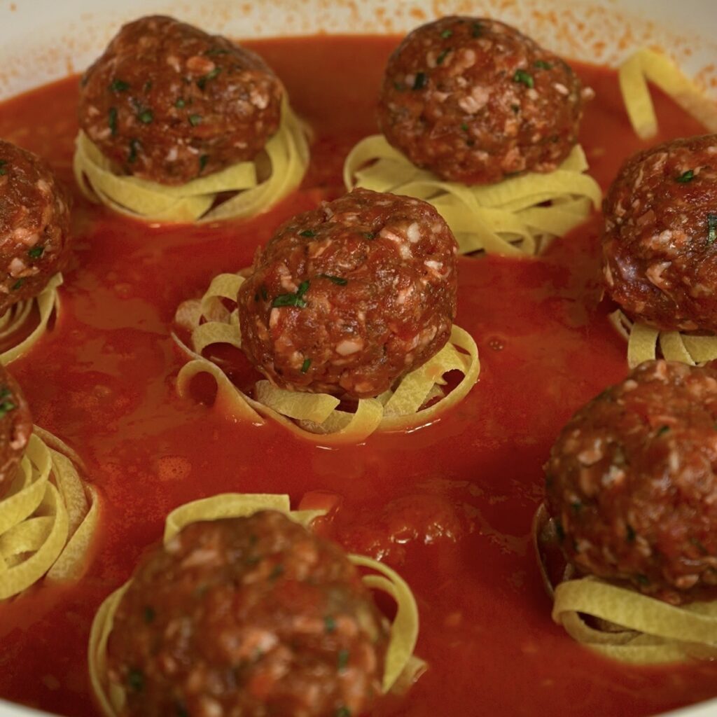 Pasta and meatballs added to the sauce