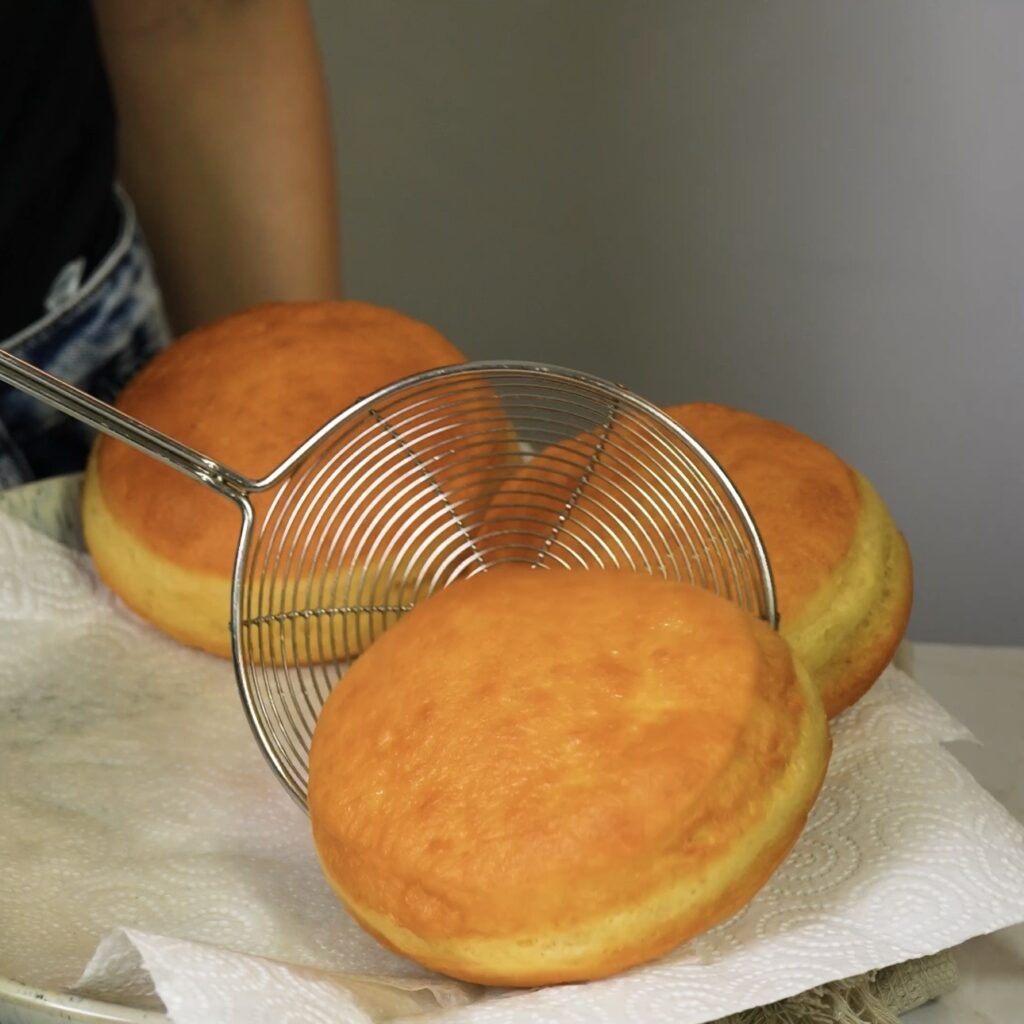 Placing fried doughnuts on paper towel