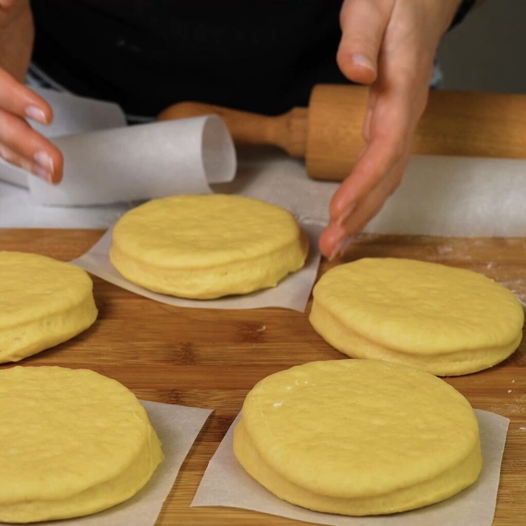 Placing dough circles on parchment paper squares