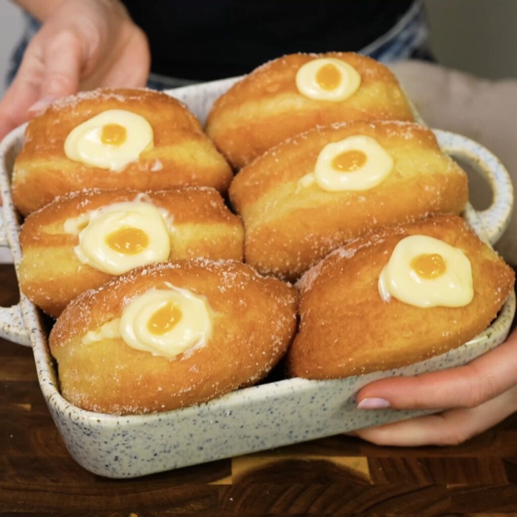 Filled and decorated doughnuts arranged in a dish