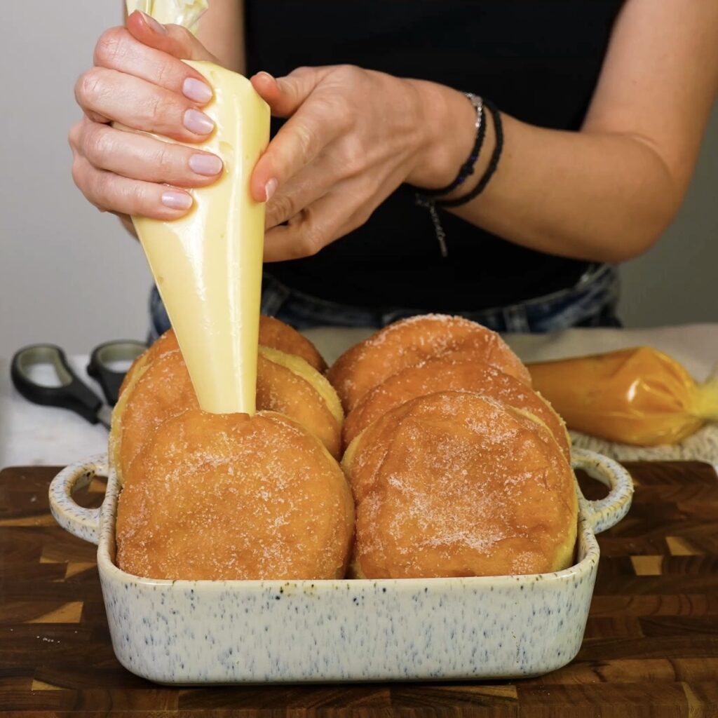 Filling doughnuts with custard using a piping bag