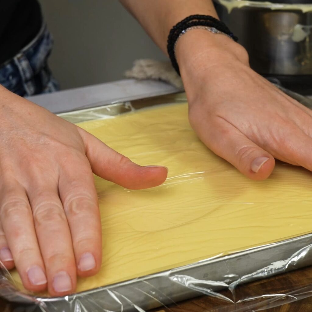 Covering custard with cling film to prevent skin