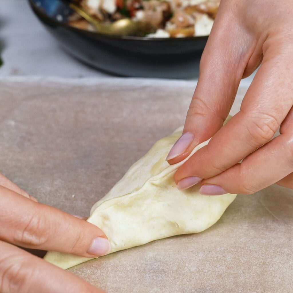 Sealing the sides of the puff pastry to form an oblong parcel.