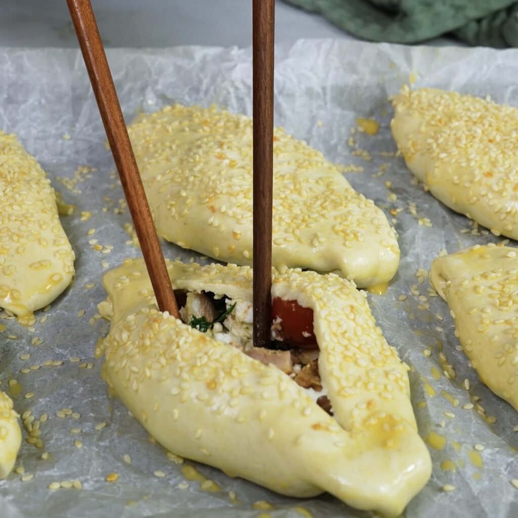 Gently opening the slit in the puff pastry.
