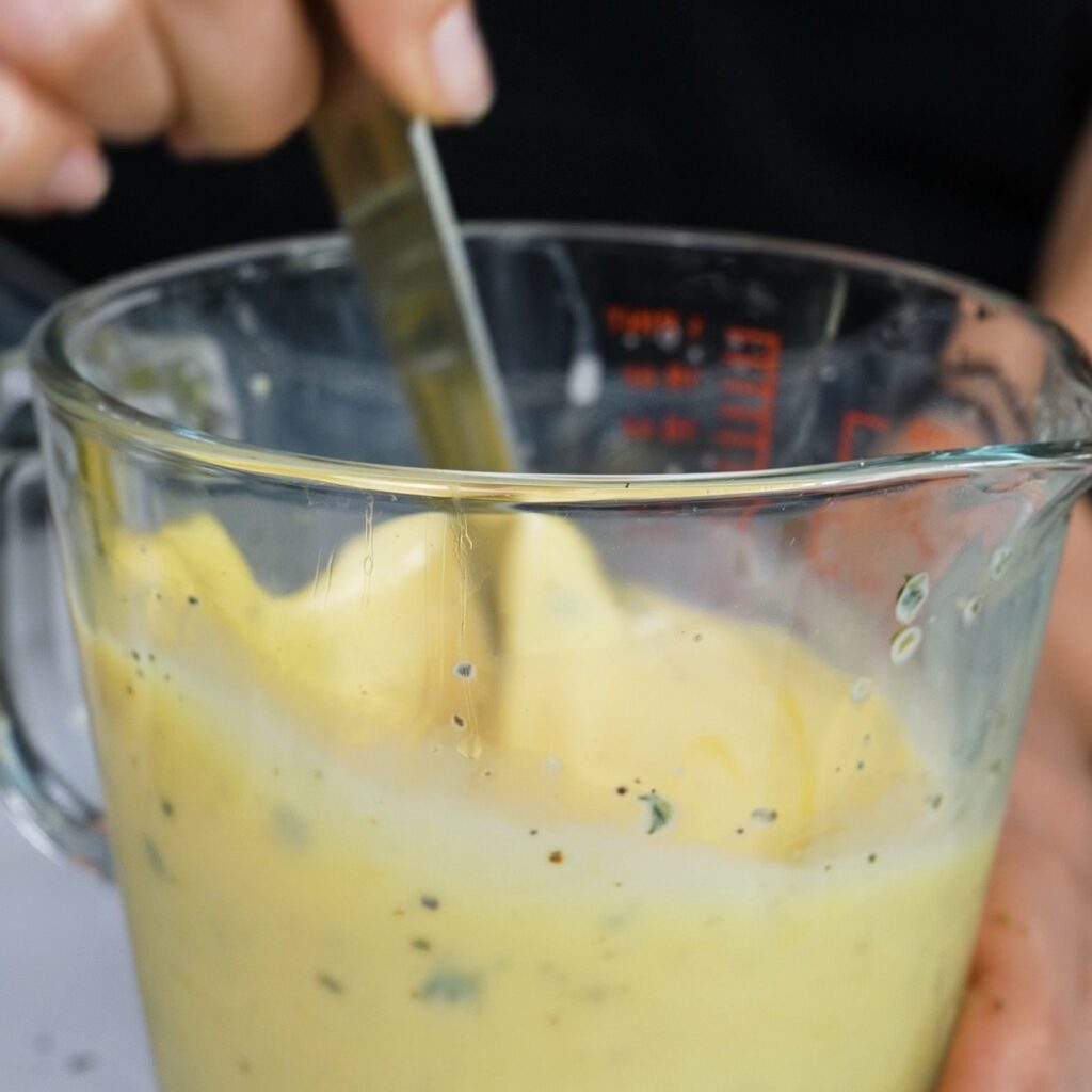 Whisking eggs and milk to make custard for puff quiches.