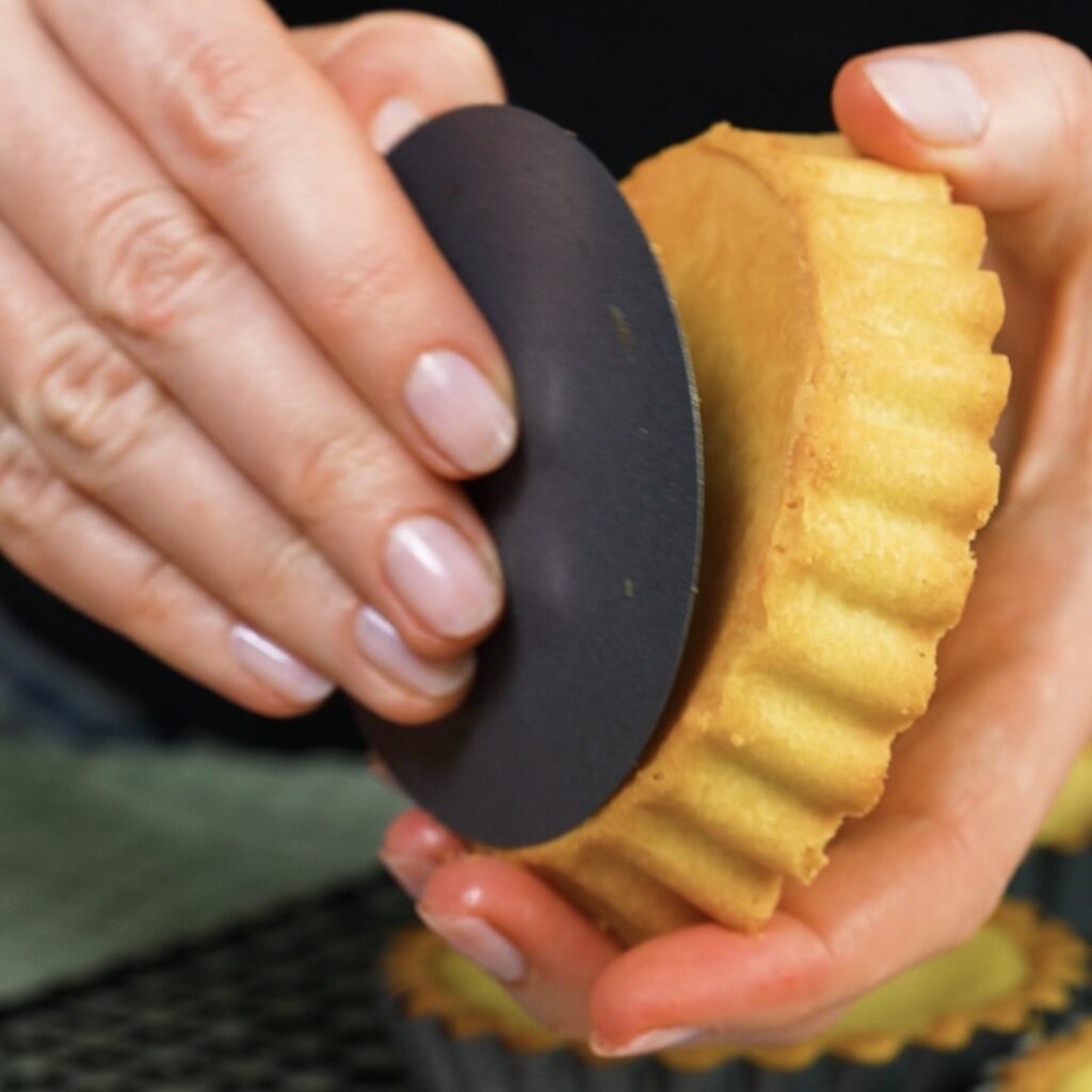 Removing a baked tartlet from the tart tin.