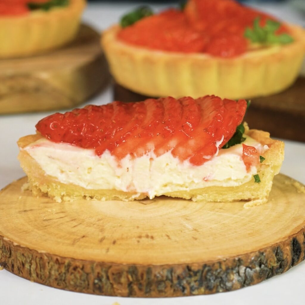 Sliced strawberry ricotta tartlet showing creamy filling.