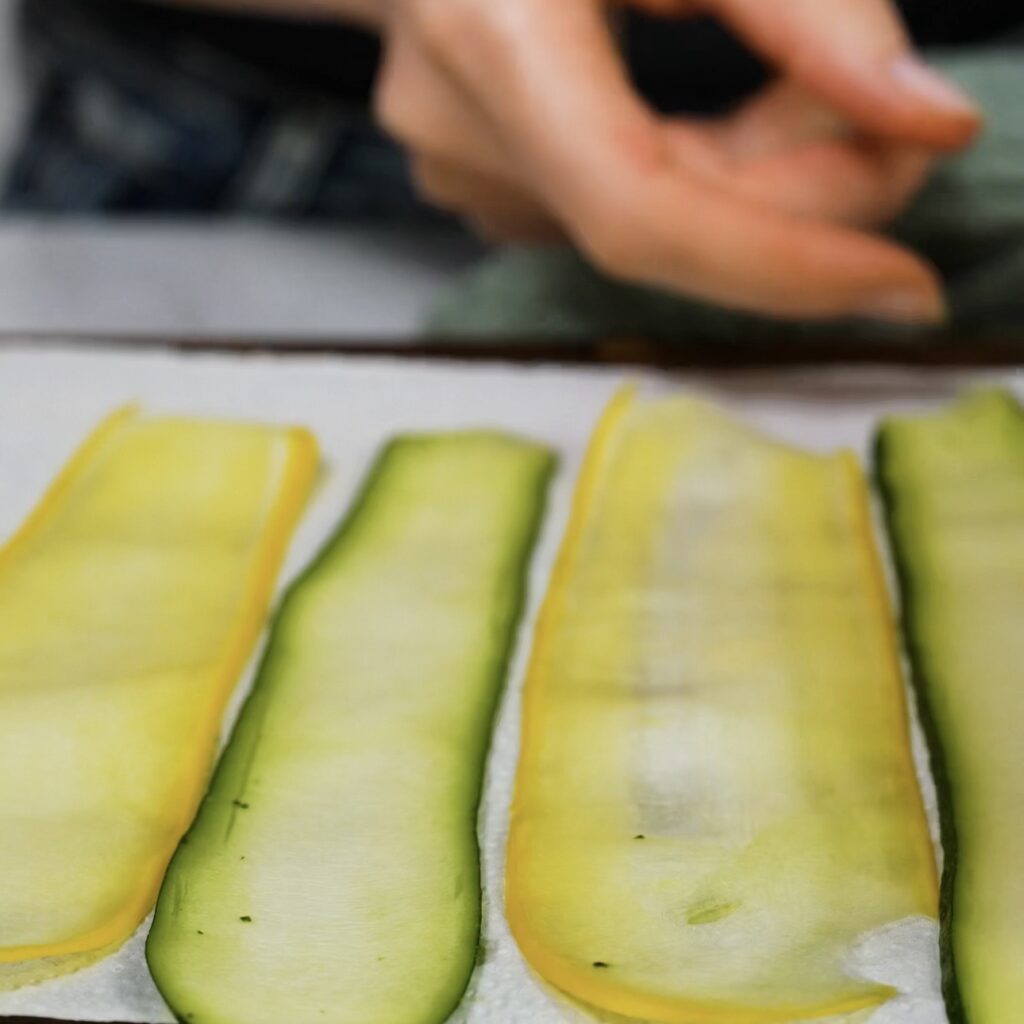 Courgette and squash ribbons resting on a kitchen towel to drain