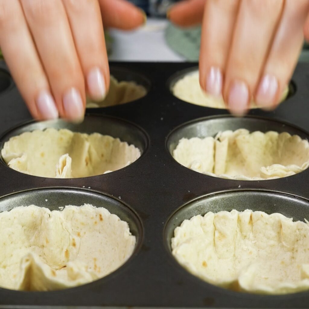 Tortilla circles pressed into a muffin tin to form tortilla cups