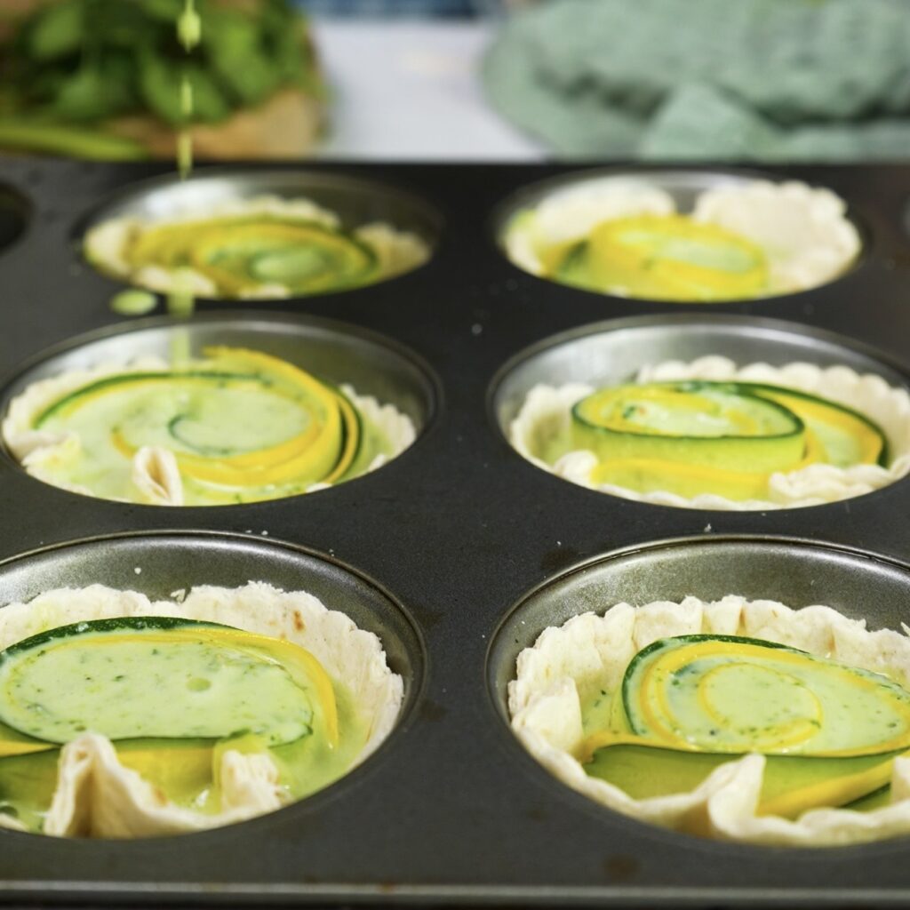 Egg and cottage cheese filling poured into tortilla cups with courgette spirals