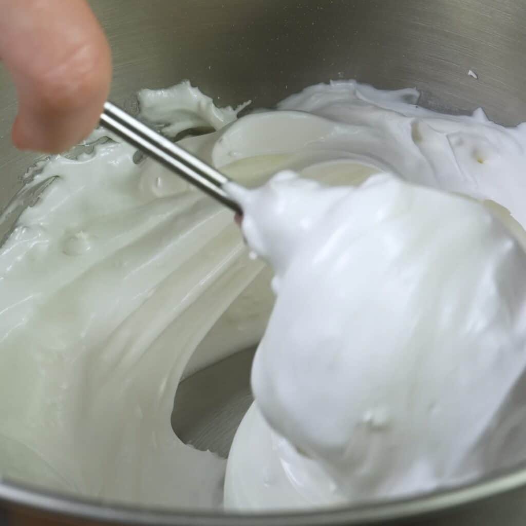 Folding cornflour and lemon juice into pavlova meringue mixture