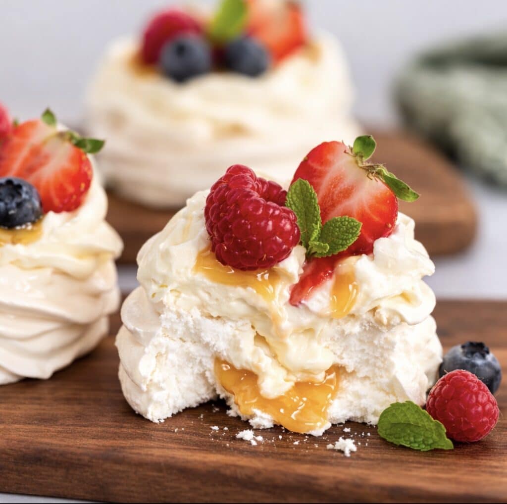 Sliced peach curd mini pavlova showing the soft centre and cream filling