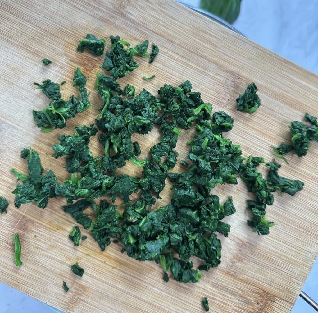 Chopped spinach on a wooden board